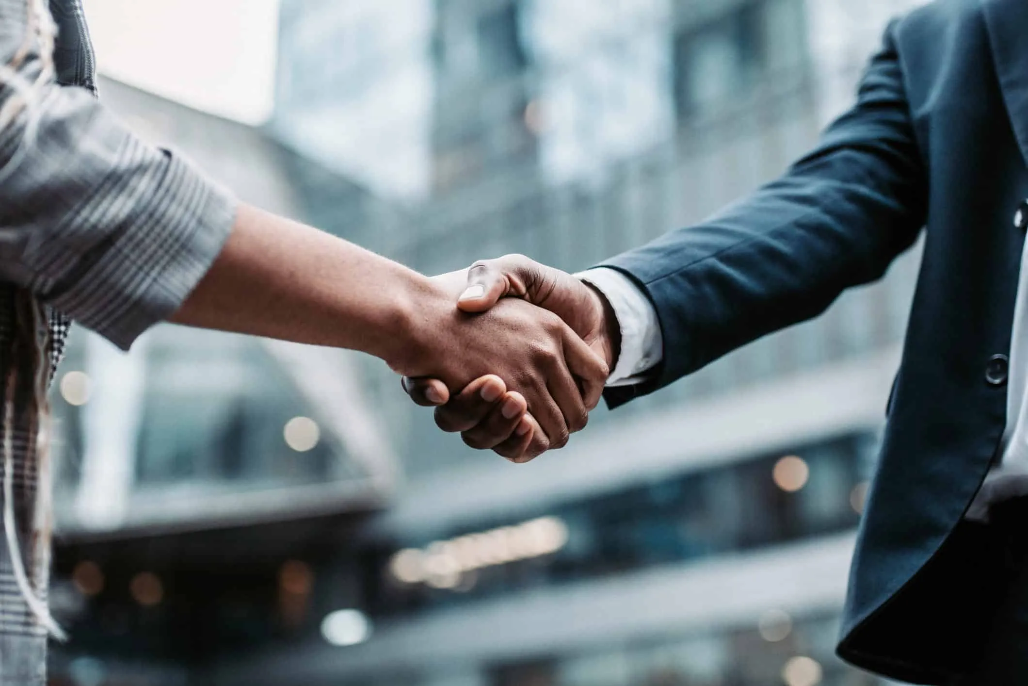 Close-up of two people in business attire shaking hands