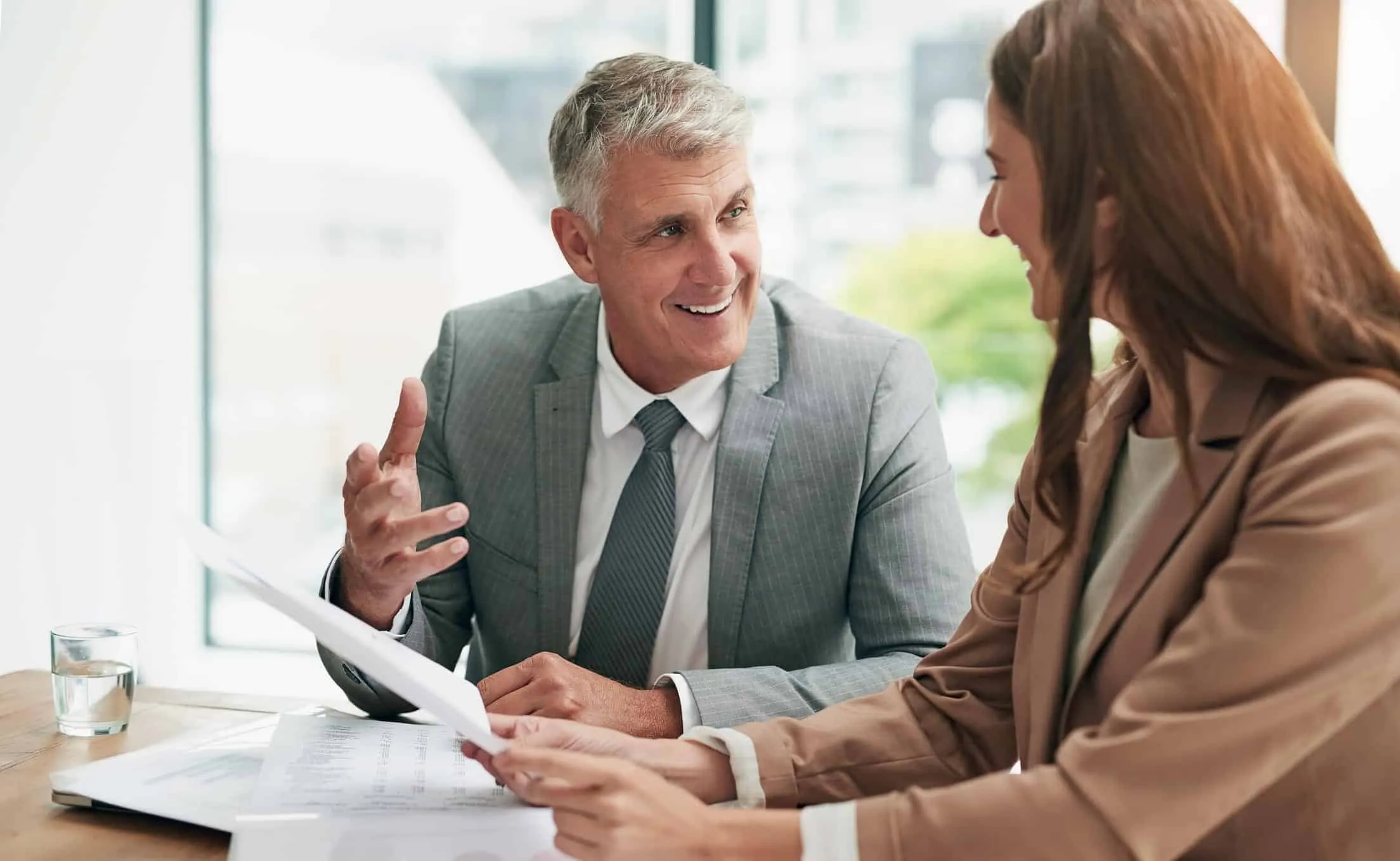 Man explaining a document to a woman at a table