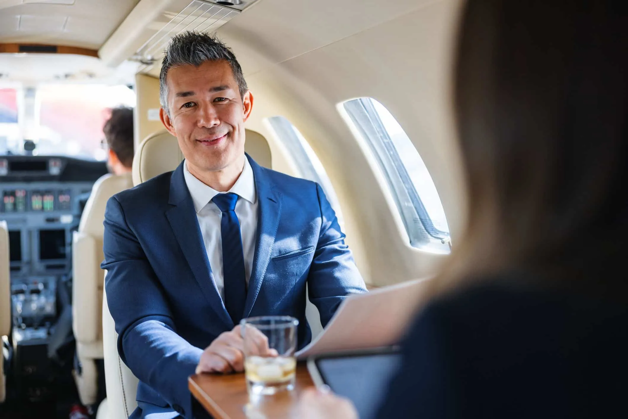 Man in a suit seated in a private jet cabin