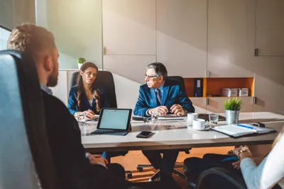 Business meeting around a conference table with a tablet and documents