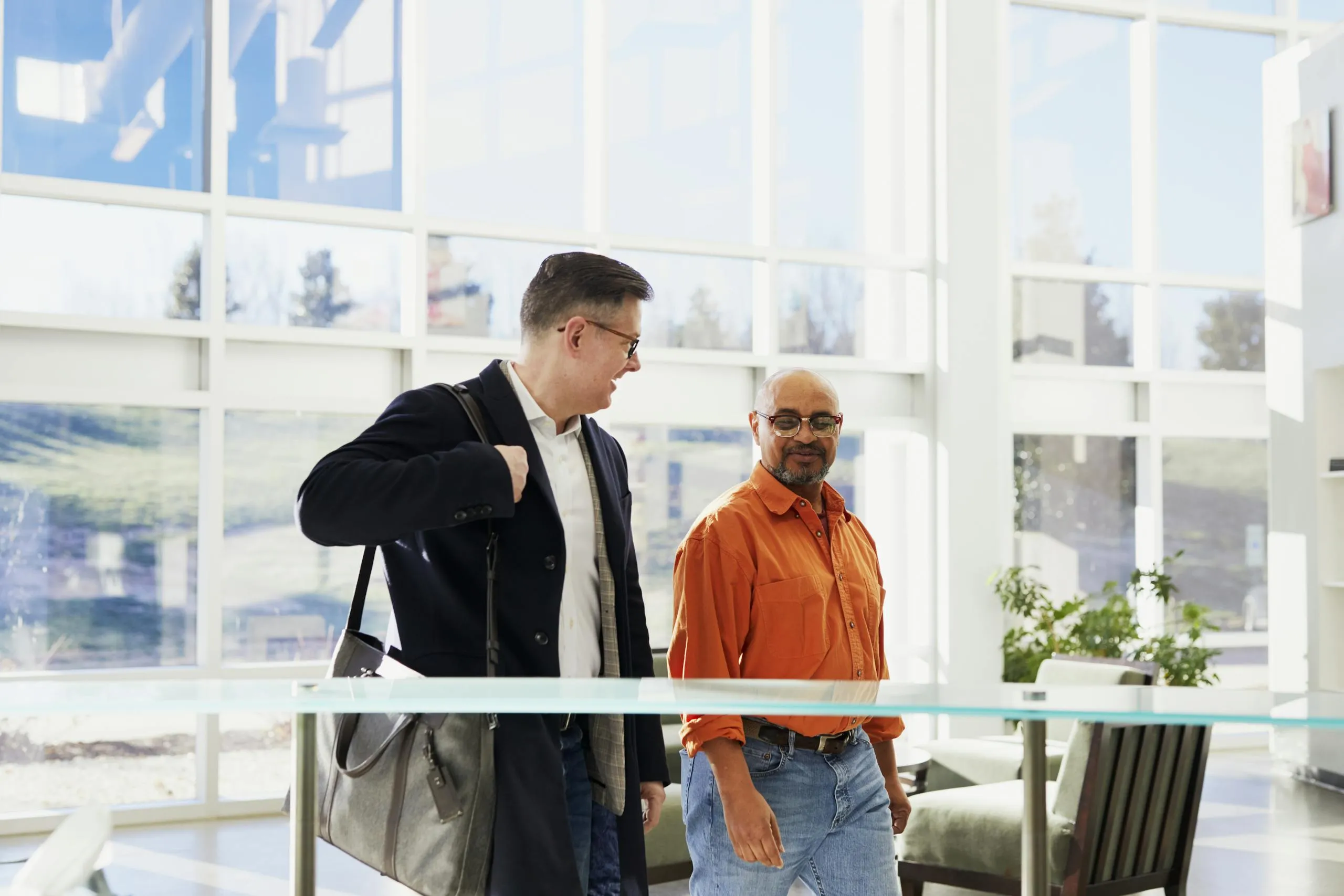 Two business professionals in a bright, modern office discussing their work.